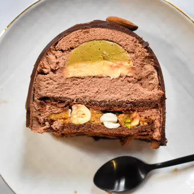 Part de Bûche mendiant (chocolat noir & fruits secs : noisette, pistache, amande)